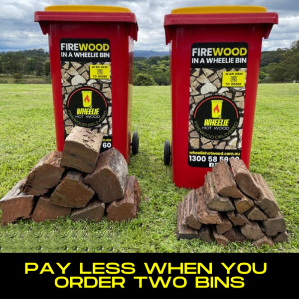 Two red wheelie bins labelled 'Firewood in a Wheelie Bin' with stacked firewood on a grassy field. One bin has a small pile of Standard Split firewood in front of it, and the other bin has a small pile of Double Split Firewood in front of it. the bottom section of the image has a black background and the words "pay less when you order two bins" in large yellow font.